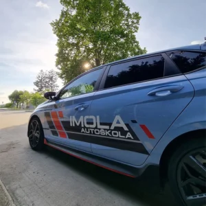 Hyundai i20N zachytený zľava v dynamickej jazde na otvorenom priestranstve