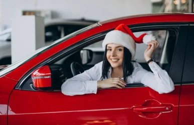 Dievča v aute so Santa čiapkou, symbolizujúce sviatočnú vianočnú ponuku vodičského kurzu v Trnave