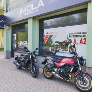 Pohľad na Kawasaki Z 650 RS a Kawasaki Eliminator 500 vedľa seba na výcvikovej ploche pred autoškolou